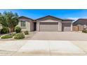 Tan home featuring a two-car garage, beautiful landscaping, and a brick driveway at 1268 E Jahns Dr, Casa Grande, AZ 85122