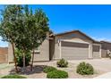 Tan home featuring a two-car garage, beautiful landscaping, and a brick driveway at 1268 E Jahns Dr, Casa Grande, AZ 85122