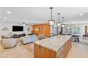 Open floor plan showcasing the kitchen island with a marble countertop and adjacent living areas at 17890 N 99Th Dr, Sun City, AZ 85373