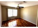 Cozy bedroom with hardwood floors, fan, and a bright window at 1836 N Stapley Dr # 88, Mesa, AZ 85203