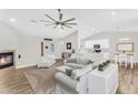 Open-concept living area featuring a cozy fireplace, modern ceiling fan, and easy access to kitchen at 18822 E Flintlock Dr, Queen Creek, AZ 85142