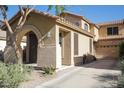 Tan stucco home featuring an arched front porch, a tile roof, and desert landscaping at 1950 W Park Pl, Chandler, AZ 85224