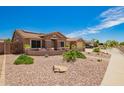 Single-story home featuring desert landscaping, solar panels, and a welcoming front porch at 20427 N 88Th Dr, Peoria, AZ 85382