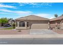 Charming single-story home with a desert landscape, tile roof, and attached two-car garage on a sunny day at 22576 N Davis Way, Maricopa, AZ 85138