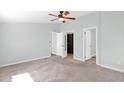 Spacious, light-filled bedroom featuring a ceiling fan, neutral carpet, and walk-in closet at 2400 E Baseline Ave # 228, Apache Junction, AZ 85119