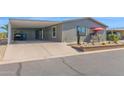 Charming home with covered carport, xeriscaped front yard, and quaint patio seating area at 2400 E Baseline Ave # 228, Apache Junction, AZ 85119