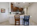 Bright eat-in kitchen with quartz countertops, stainless appliances, and dark wood cabinets at 2511 W Queen Creek Rd # 337, Chandler, AZ 85248