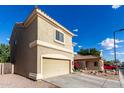 A side view of a two-story tan stucco home with a two car garage at 337 N 103Rd Pl, Apache Junction, AZ 85120