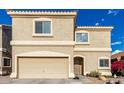 Close-up of a two-story tan stucco home with a two car garage at 337 N 103Rd Pl, Apache Junction, AZ 85120