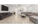 Open concept living area features a gray sectional, tile floors, neutral paint and easy access to the kitchen at 343 S 202Nd Dr, Buckeye, AZ 85326