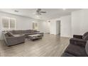 Spacious living room with neutral walls, gray sofas, tile flooring, ceiling fan, and plenty of natural light at 343 S 202Nd Dr, Buckeye, AZ 85326