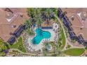 Aerial shot showcasing the community pool with inviting turquoise waters and palm tree landscaping at 3800 S Cantabria Cir # 1077, Chandler, AZ 85248