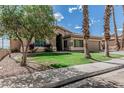 Single-story home with well-kept lawn, mature trees, and desert landscaping at 408 N Falcon Ct, Gilbert, AZ 85234