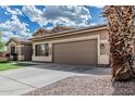 This home features a two-car garage with a large driveway and desert landscaping at 408 N Falcon Ct, Gilbert, AZ 85234