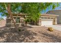 Inviting single-Gathering house with well-manicured landscaping, stone accents, and a spacious driveway leading to a two-car garage at 44574 W High Desert Trl, Maricopa, AZ 85139
