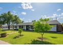 Quaint single-story house featuring lush green lawn and landscaping with trees, creating a tranquil neighborhood setting at 4502 N 17Th Ave, Phoenix, AZ 85015