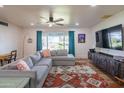 Cozy living room featuring a plush sectional sofa, floor lamp, and large window with view of the front yard at 4502 N 17Th Ave, Phoenix, AZ 85015