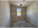 Unfinished bedroom with bare drywall and window, offering a blank canvas for customization at 46887 W Old Timer Rd, Maricopa, AZ 85139