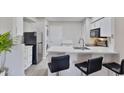 Modern kitchen featuring white cabinets, stainless steel appliances, breakfast bar seating, and a stackable washer/dryer at 4901 S Calle Los Cerros Dr # 119, Tempe, AZ 85282