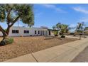 Wide angle view of a white stucco home showcasing the drought resistant landscaping at 6401 E Voltaire Ave, Scottsdale, AZ 85254