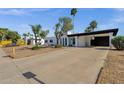 Front of a stucco home featuring a black carport and desert landscaping at 6401 E Voltaire Ave, Scottsdale, AZ 85254