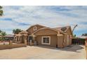 View of the house showing the driveway and access to the backyard, featuring a neutral color scheme at 6701 W Catalina Dr, Phoenix, AZ 85033