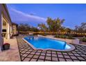 Beautiful backyard showcasing a large pool and meticulously designed travertine and grass paver design at 7327 E La Junta Rd, Scottsdale, AZ 85255