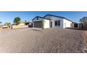 Charming single-story home featuring gray 2-car garage, gravel landscaping, and modern design at 8679 W Raven Dr, Arizona City, AZ 85123