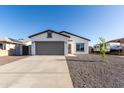 Charming single-story home featuring gray 2-car garage, gravel landscaping, and modern design at 8679 W Raven Dr, Arizona City, AZ 85123