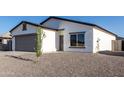 Charming single-story home featuring gray 2-car garage, gravel landscaping, and modern design at 8679 W Raven Dr, Arizona City, AZ 85123