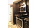 Updated kitchen featuring granite countertops, stainless steel appliances, and dark cabinetry at 913 E Beryl Ave, Phoenix, AZ 85020