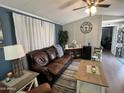 Well-lit living area features cozy seating, neutral flooring, and a ceiling fan at 9302 E Broadway Rd # 49, Mesa, AZ 85208