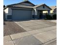 Well-maintained home with a two-car garage and desert-style front yard landscaping at 9438 E Plana Ave, Mesa, AZ 85212