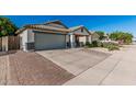 A single-story home features a two-car garage and desert landscaping at 9438 E Plana Ave, Mesa, AZ 85212