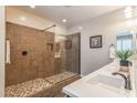 Bathroom featuring a tiled walk-in shower with glass door and a white single sink vanity at 10539 E Corbin Ave, Mesa, AZ 85212
