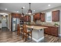 Stylish kitchen with granite island, stainless steel appliances, custom cabinets, and wood-look flooring at 10539 E Corbin Ave, Mesa, AZ 85212
