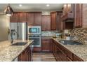 Modern kitchen with stainless steel appliances, granite countertops, mosaic backsplash, and custom cabinetry at 10539 E Corbin Ave, Mesa, AZ 85212