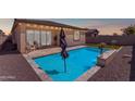 Backyard pool area featuring a modern design, ample patio space with exterior lights, and neutral colors at 11357 E Unger Ave, Mesa, AZ 85212
