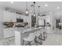 Bright and stylish kitchen with white cabinets, stainless steel appliances, large island and decorative pendant lighting at 11357 E Unger Ave, Mesa, AZ 85212