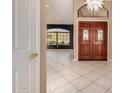 Inviting home foyer with tiled flooring, a modern chandelier, and paneled double doors that enhance the home's aesthetic at 1590 W Desert Broom Dr, Chandler, AZ 85248