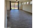 Spacious living room with tiled flooring, ceiling fan, and sliding glass doors leading to the backyard at 15951 W Yavapai St, Goodyear, AZ 85338