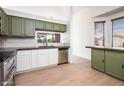 Bright kitchen featuring green and white cabinetry, stainless steel appliances, and wood flooring at 1642 E Palm Beach Dr, Chandler, AZ 85249
