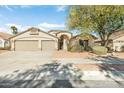 Charming single-story home with a three-car garage, desert landscaping, and mature shade trees at 16648 W Adams St, Goodyear, AZ 85338