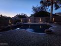Backyard pool illuminated with decorative lighting highlighting the privacy wall at dusk at 16648 W Adams St, Goodyear, AZ 85338