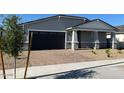 Charming single-story home with a brick-paved driveway and a well-manicured front yard at 17677 W Odeum Ln, Goodyear, AZ 85338