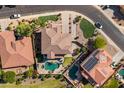 A bird's eye view reveals a home with a pool, green lawn, and perfectly placed landscaping at 18330 W Woodrow Ln, Surprise, AZ 85388