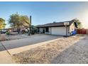 Traditional single-story house featuring a two-car garage, desert landscaping and driveway basketball court at 19604 N 13Th Ave, Phoenix, AZ 85027