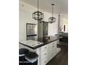 Bright kitchen featuring a large island with modern light fixtures and white cabinets at 2249 E Pinto Dr, Gilbert, AZ 85296