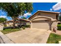 Charming single-Gathering home featuring a beige exterior, desert landscaping and a two-car garage at 23813 S Pleasant Way, Sun Lakes, AZ 85248
