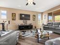 Spacious living room features wood flooring, modern furnishings, and bright windows for a welcoming atmosphere at 25540 N 103Rd Dr, Peoria, AZ 85383